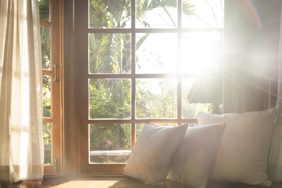 Living room with part of sofa in sunny day and white cushion interior background concept. property