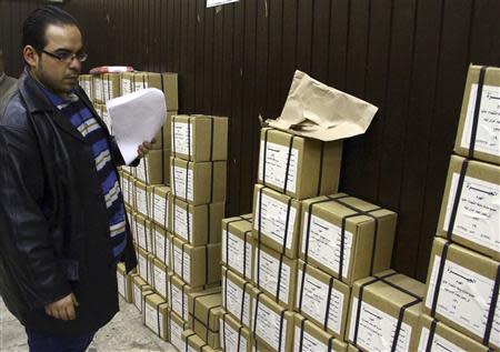 An election official stands next to boxes containing voting slips for a referendum on the new constitution in Cairo January 12, 2014. REUTERS/Al Youm Al Saabi Newspaper