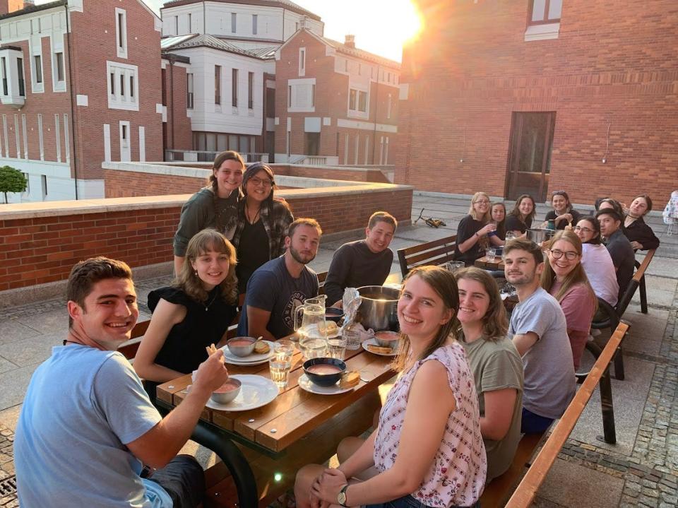 Noah Bock of Temperance and other camp volunteers have dinner outdoors at the Saint John Paul II Polish Center in Krakow, Poland.