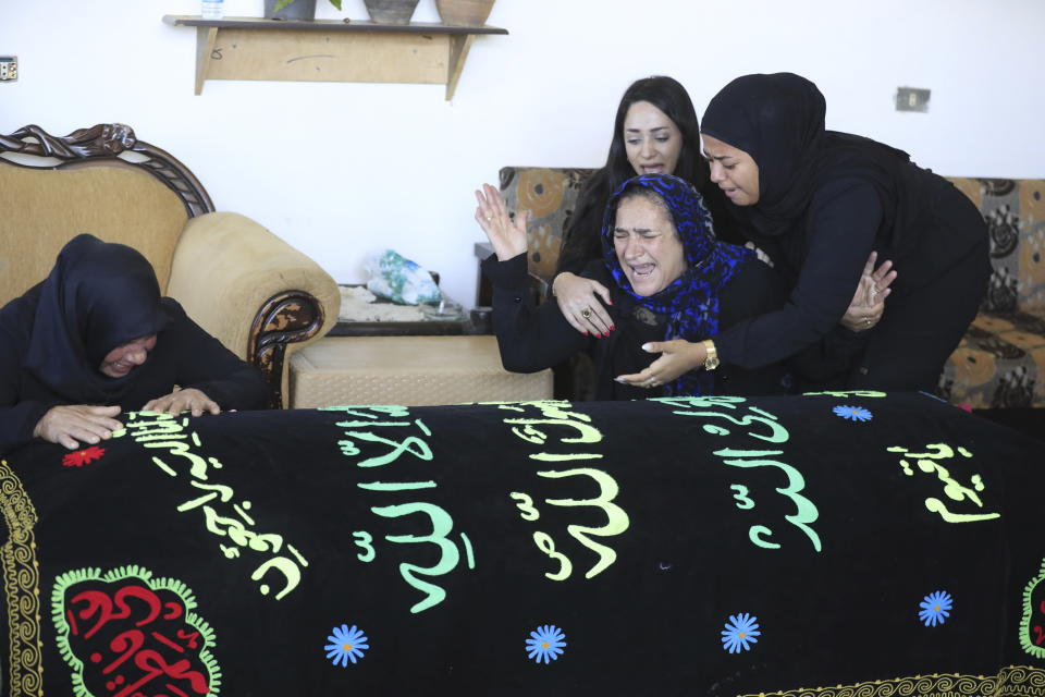 Relatives of the victims weep over the coffins in the town of Ainata, a Lebanese border village with Israel in south Lebanon, Tuesday, Nov. 7, 2023. A Lebanese woman and her three grand daughters were laid to rest in their hometown in southern Lebanon two days after they were killed in an Israeli drone strike while in a car near the Lebanon-Israel border. (AP Photo/Mohammed Zaatari)