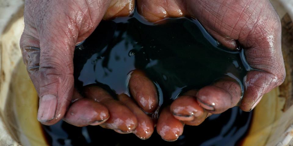 pair of hands cupped holding crude oil