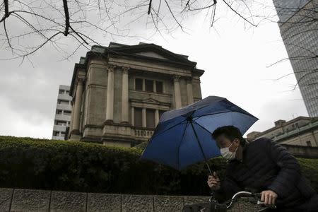 A businessman cycles past the Bank of Japan (BOJ) headquarters in Tokyo, Japan, February 15, 2016. REUTERS/Thomas Peter