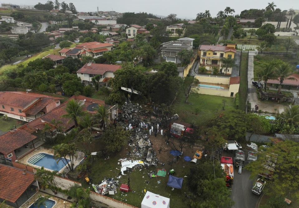 Firefighters and rescue teams work at the site in a residential area where an airplane with 61 people on board crashed in Vinhedo, Sao Paulo state, Brazil. (AP Photo/Andre Penner)