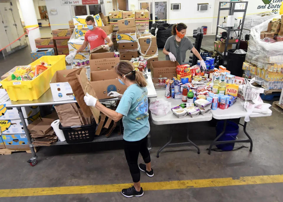 Volunteers sort out food from area grocery stores into boxes to be donated at the Food Bank of Central & Eastern North Carolina in Wilmington.