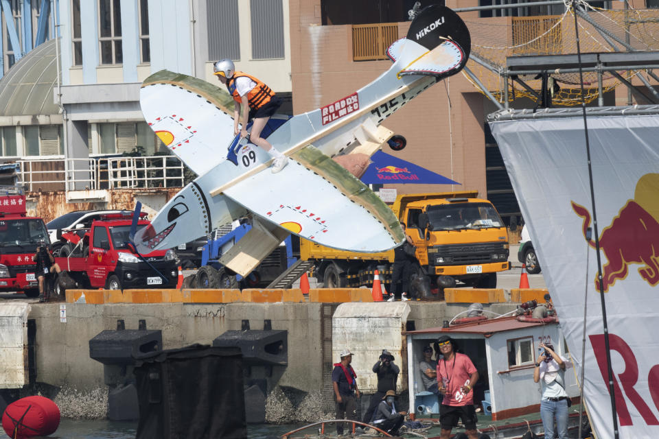 A team member jumps from a platform with a man made flying machine into the harbor in Taichung, a port city in central Taiwan on Sunday, Sept. 18, 2022. Pilots with homemade gliders launched themselves into a harbor from a 20-foot-high ramp to see who could go the farthest before falling into the waters. It was mostly if not all for fun as thousands of spectators laughed and cheered on 45 teams competing in the Red Bull “Flugtag” event held for the first time. (AP Photo/Szuying Lin)