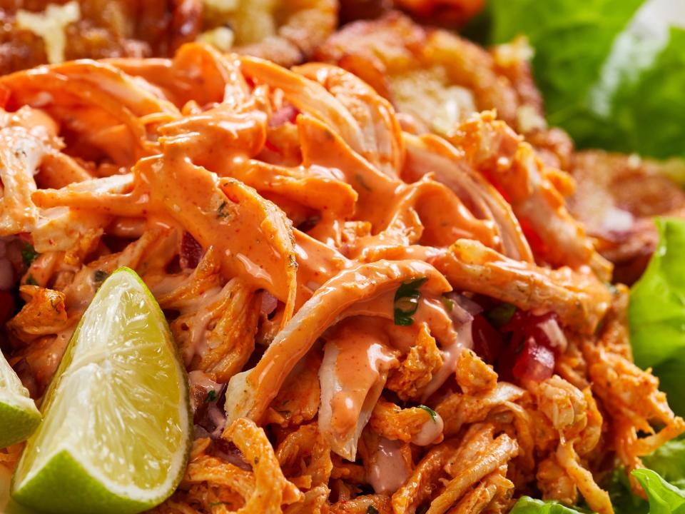 shredded buffalo chicken with lime wedge