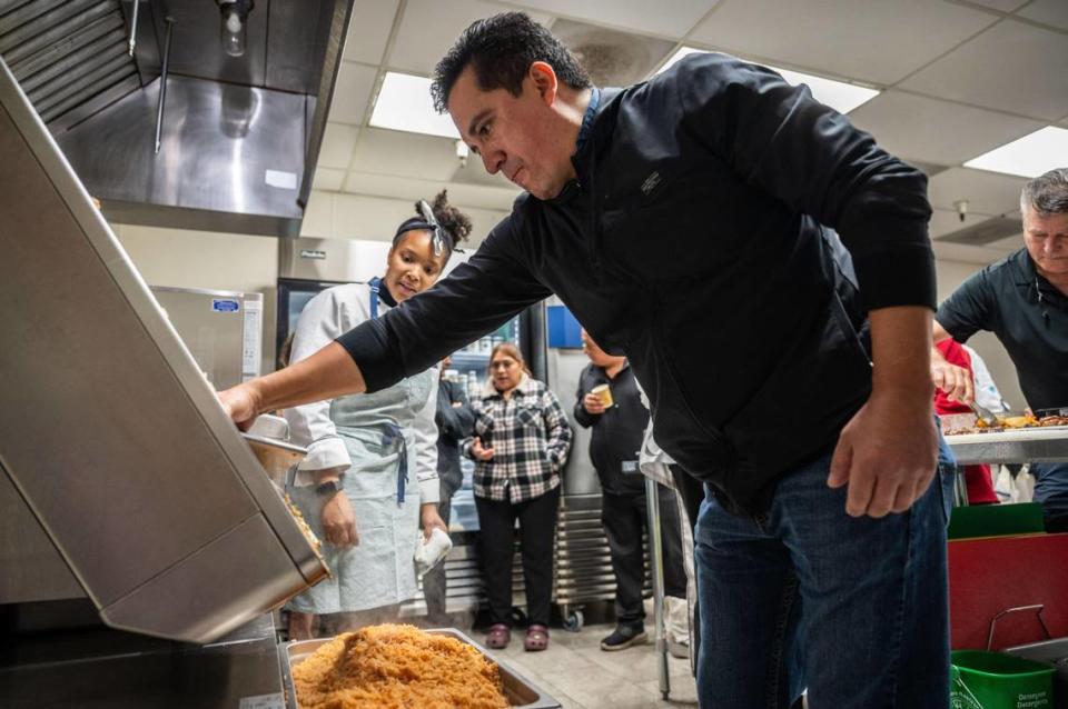 Victor Guzman, general manager at La Cosecha pours rice that was cooked on the iVario Pro cooking system Nov. 13 during a SMUD and Fantastic Kitchen demonstration on the benefits of electrification within cooking - particularly when it comes to Mexican dishes.