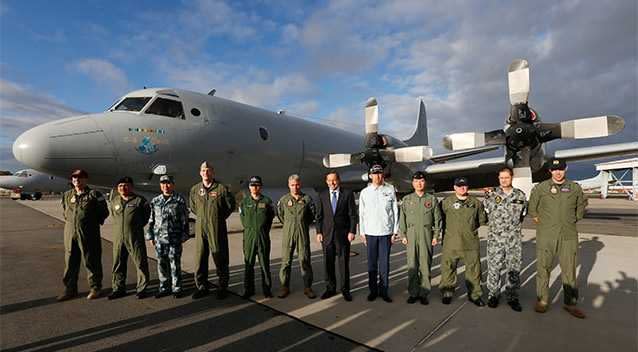 Australian Prime Minister Tony Abbott, 6th from right, poses with leaders of international military operations currently based in Australia searching for the missing Malaysia Airlines Flight MH370 in front of a Royal Australian Air Force P-3C Orion search aircraft. Photo: AP.