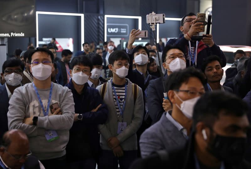 FILE PHOTO: Visitors use their mobile phones to film vehicles at the India Auto Expo 2020 in Greater Noida