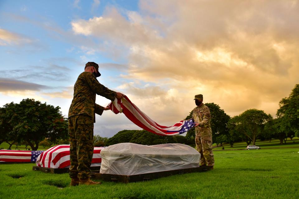 Service members with the military's Defense POW/MIA Accounting Agency place a flag on a casket during a disinterment ceremony in October 2020 at the National Memorial Cemetery of the Pacific in Hawaii as part of the agency's efforts to disinter remains of unknown service members lost during WWll. The remains of a Ventura sailor killed in the 1941 attack on Pearl Harbor were identified in May.