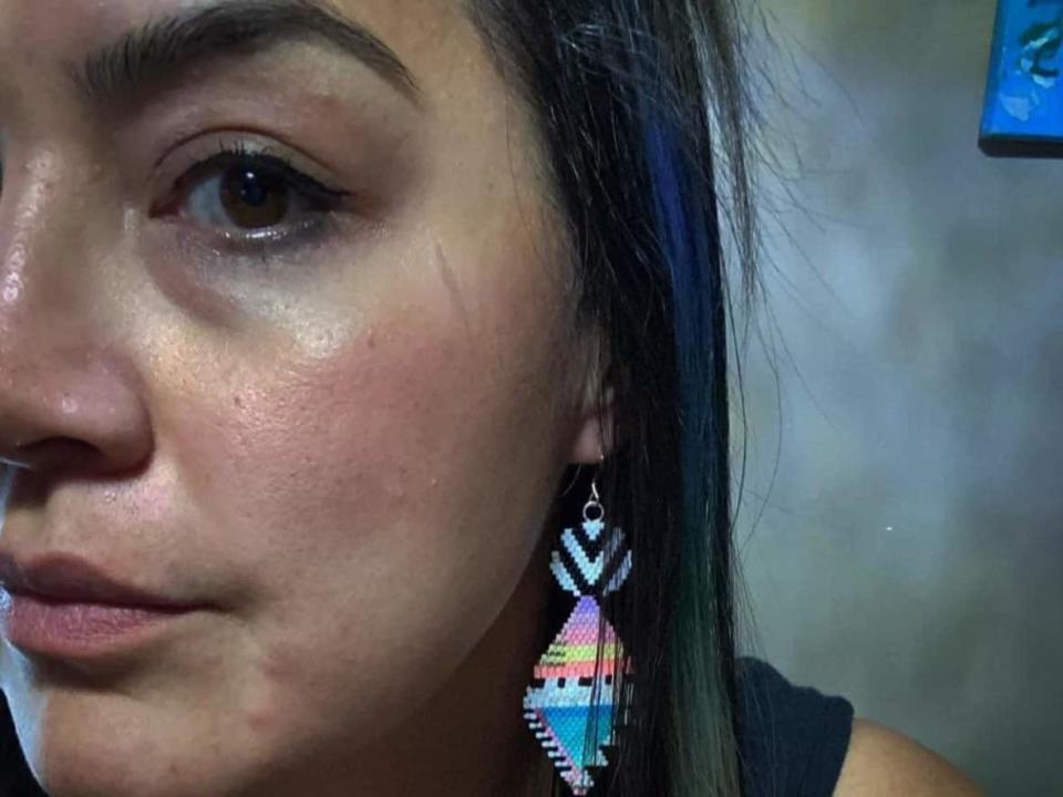 Inuvik-based artist Erica Donovan, seen here wearing beaded earrings she made,  had five pairs of earrings listed on Simon's Fabrique 1840 website. They sold out within a day. (Submitted by Erica Donovan - image credit)