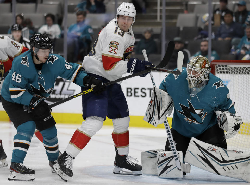 San Jose Sharks' Joel Kellman, left, and goalie Aaron Dell, right, defend against Florida Panthers' Mark Pysyk (13) in the second period of an NHL hockey game Monday, Feb. 17, 2020, in San Jose, Calif. (AP Photo/Ben Margot)