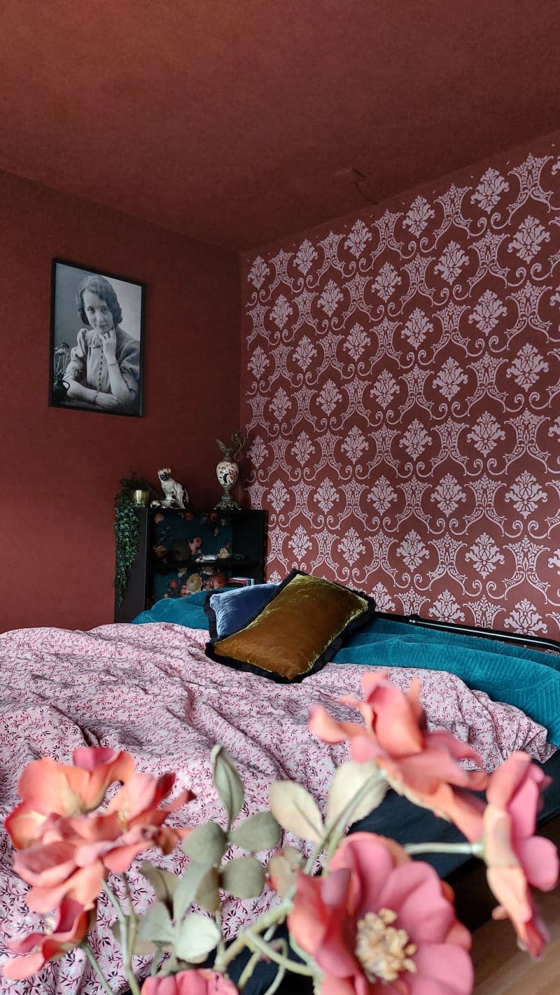 A red bedroom with a red and white accent wall