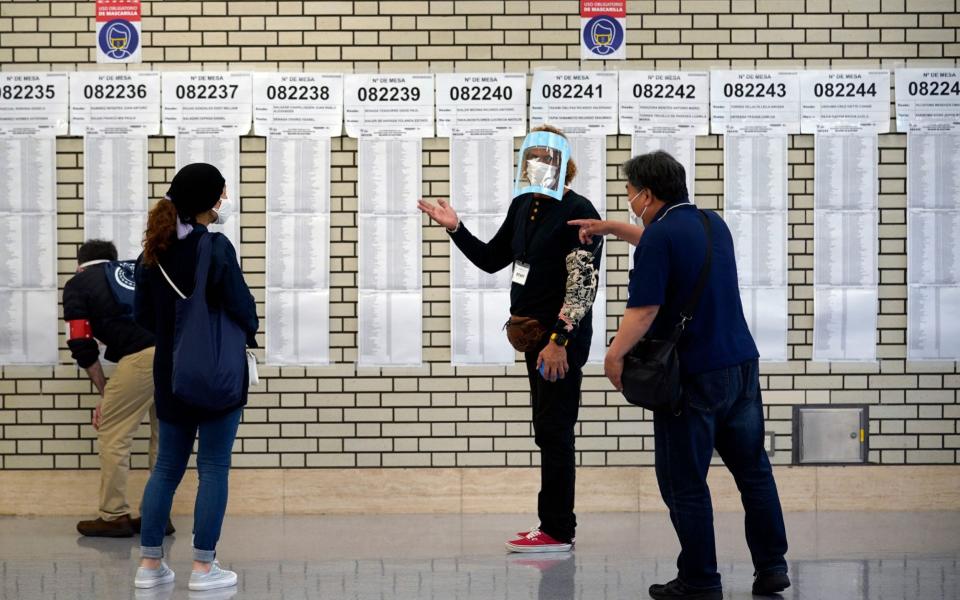 Peruvian nationals living in Japan gather before voters lists at a polling station in Tokyo, Japan, - Shutterstock