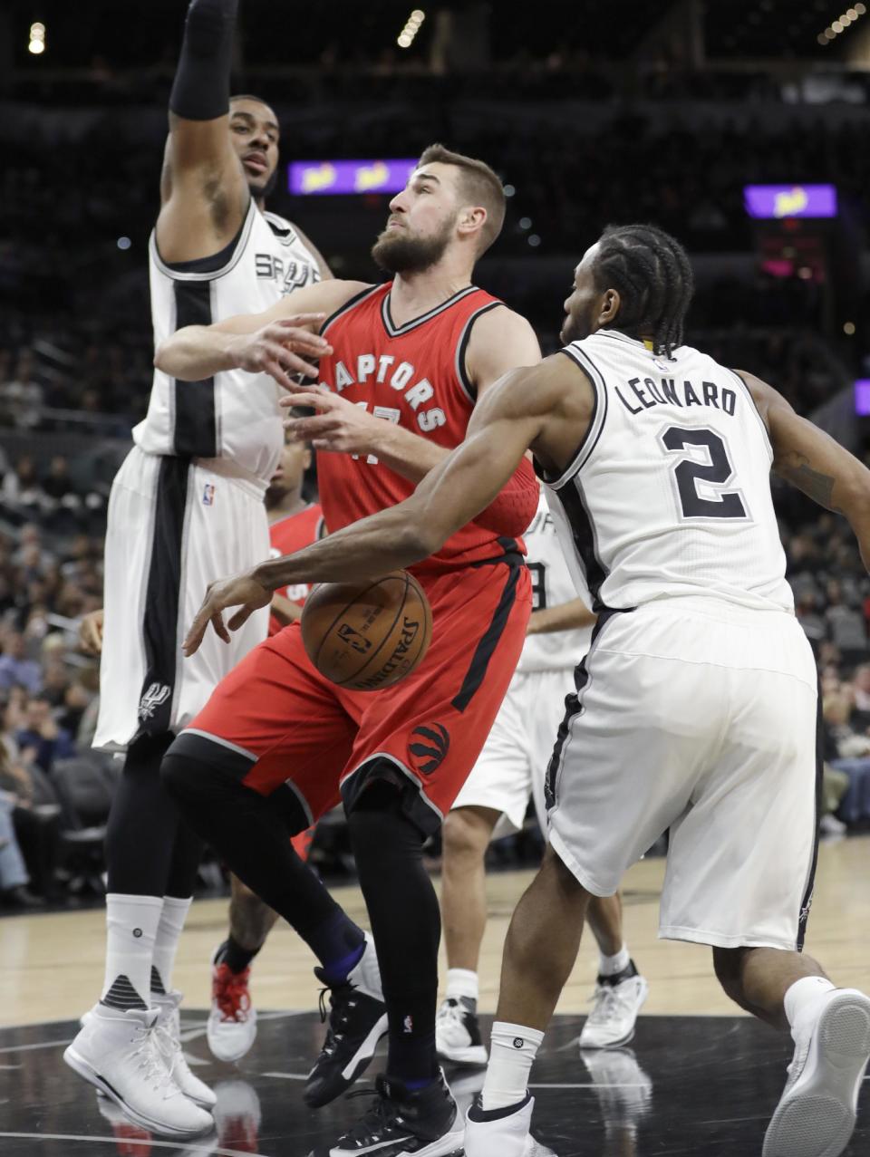 Toronto Raptors center Jonas Valanciunas (17) is stripped of the ball by San Antonio Spurs forward Kawhi Leonard (2) during the first half of an NBA basketball game, Tuesday, Jan. 3, 2017, in San Antonio. (AP Photo/Eric Gay)