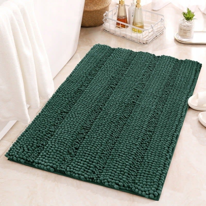 Textured green bath mat on a bathroom floor