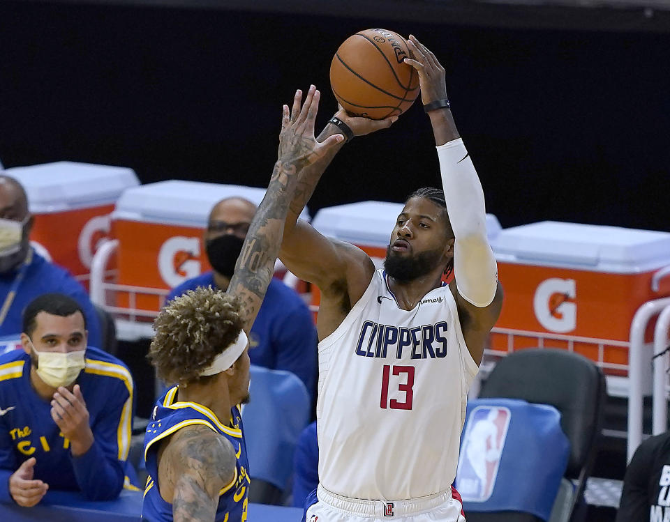 Los Angeles Clippers guard Paul George (13) takes a 3-point shot over Golden State Warriors forward Kelly Oubre Jr. during the second half of an NBA basketball game in San Francisco, Friday, Jan. 8, 2021. (AP Photo/Tony Avelar)