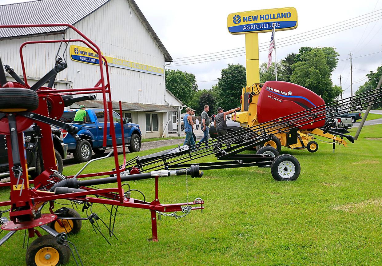 Customers check out a baler on display at Ashland Tractor on Tuesday, June 7, 2022. TOM E. PUSKAR/TIMES-GAZETTE.COM