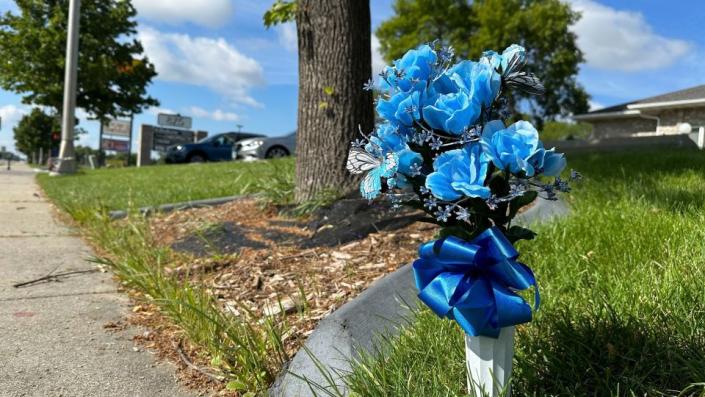 Flowers rest near the site where one police officer was fatally shot and two others were critically wounded Friday. - Jack Dura/AP