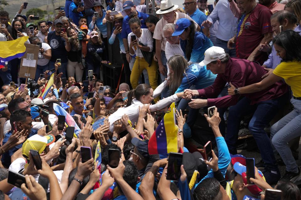 La líder opositora venezolana María Corina Machado, es llevada hasta el escenario en volandas a su llegada al inicio de la campaña del candidato a la presidencia, Edmundo González Urrutia, en La Victoria, Venezuela, el 18 de mayo de 2024. (AP Foto/Ariana Cubillos)