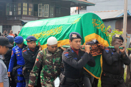 Indonesian security forces carry the body of a police officer who was shot and killed near Freeport-McMoRan Inc's giant Grasberg copper mine, during his funeral in Timika, Papua province Indonesia November 15, 2017 in this photo taken by Antara Foto. Antara Foto/Jeremias Rahadat/ via REUTERS