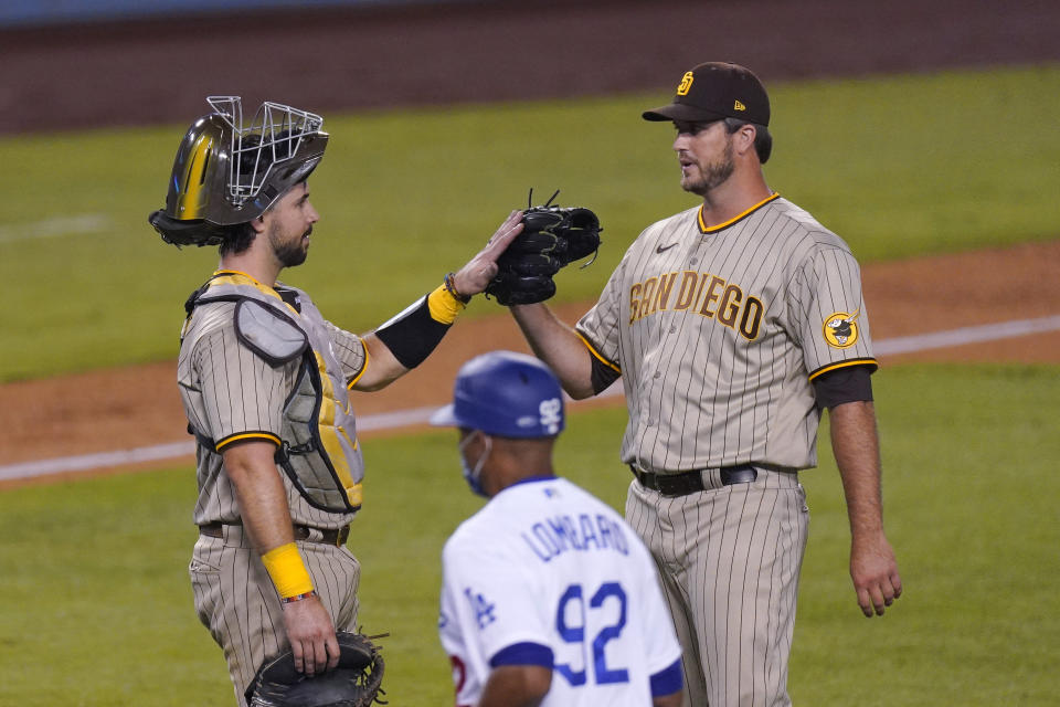 San Diego Padres catcher Austin Hedges, left, and closing pitcher Drew Pomeranz congratulate each other after the Padres defeated the Los Angeles Dodgers 6-2 in a baseball game Tuesday, Aug. 11, 2020, in Los Angeles. (AP Photo/Mark J. Terrill)