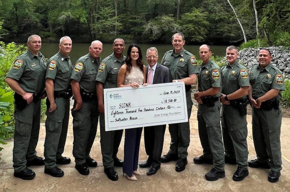 Officers from the SCDNR Law Enforcement Division formally receive an $18,500 grant from Duke Energy during a presentation in Great Falls on June 19. Tyson Blanton, of Duke Energy (center, behind check), and state Sen. Mike Fanning were on hand.