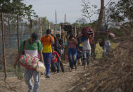 En esta imagen, tomada el 31 de agosto de 2018, venezolanos cruzan ilegalmente la frontera con Colombia, a Villa del Rosario, por una ruta conocida como "trocha". Fuera del control de las autoridades venezolanas o colombianas, las trochas están gestionadas por bandas de hombres armados con rifles y vestidos de uniforme. Cobran a los migrantes unos 10 dólares por pasar, y suelen robar o asaltar a quienes no pueden pagar. (AP Foto/Ariana Cubillos)