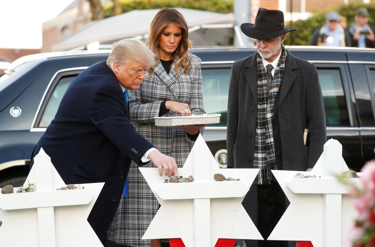 President Trump places a stone as he stands with first lady Melania Trump and Rabbi Jeffrey Myers at a makeshift memorial for the victims of the Tree of Life Synagogue massacre in Pittsburgh, Oct. 30, 2018. (Kevin Lamarque/Reuters)