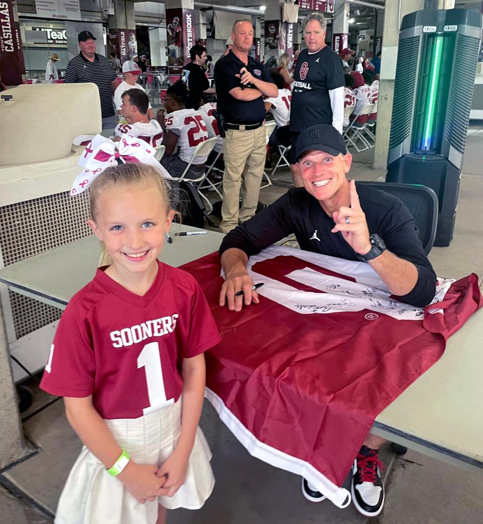 Gracie Kroth, 8, at Saturday's Meet the Sooners getting an autograph from OU football coach Brent Venables.
