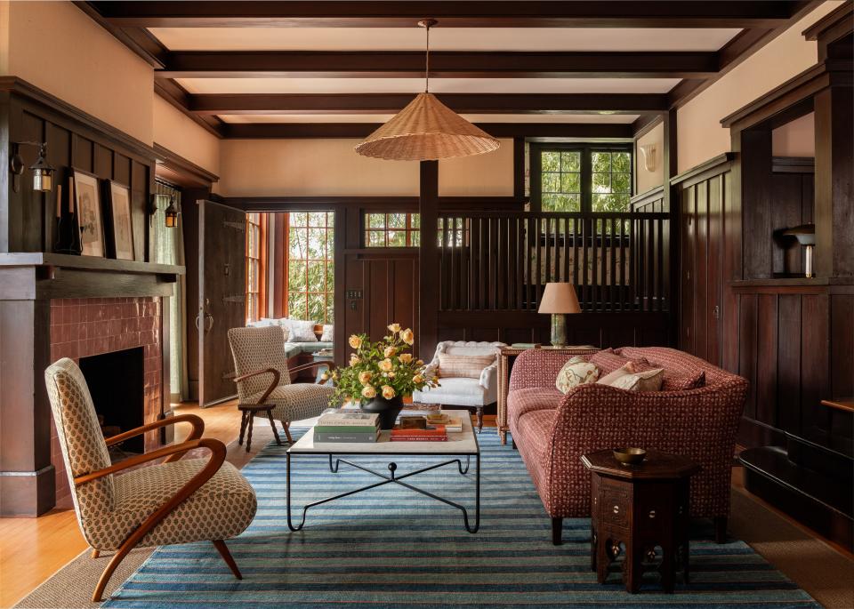 In the living room of a 1920s craftsman home in Berkeley, California, Heidi Caillier brought in a homey yet sophisticated feel with an Atelier Vime pendant, a Pinch London sofa upholstered in a Robert Kime fabric, and a pair of vintage French chairs in a Michael S. Smith fabric. The fireplace was enhanced with new Clé tile.