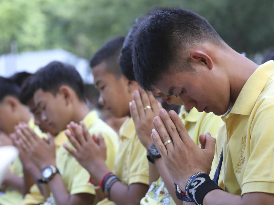 Members of the Wild Boars soccer team who were rescued from a flooded cave, pray during a religious ceremony near the Tham Luang cave in Mae Sai, Chiang Rai province, Thailand Monday, June 24, 2019. The 12 boys and their coach attended a Buddhist merit-making ceremony at the Tham Luang to commemorate the one-year anniversary of their ordeal that saw them trapped in a flooded cave for more than two weeks. (AP photo/Sakchai Lalit)