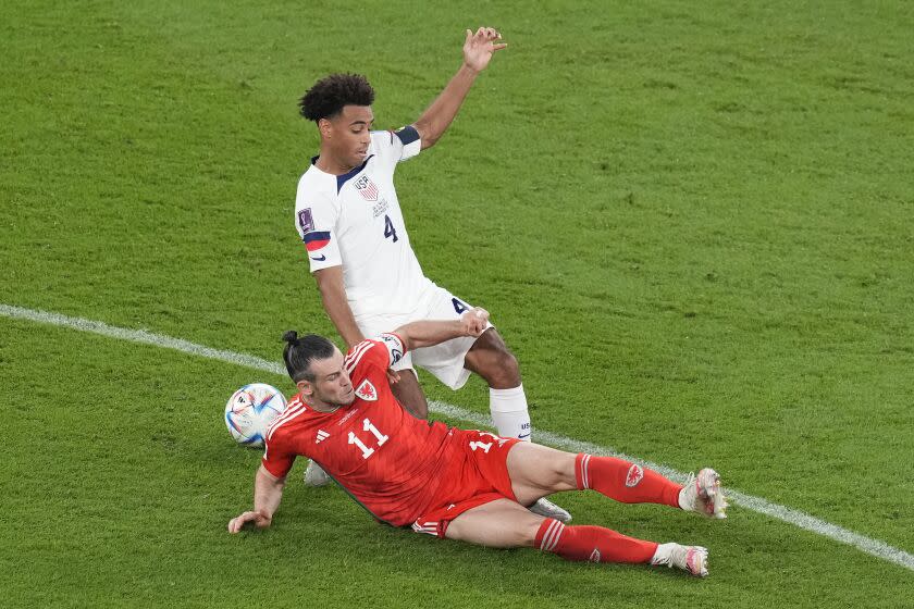 Wales' Gareth Bale, bottom, challenges Tyler Adams of the United States during the World Cup, group B soccer match between the United States and Wales, at the Ahmad Bin Ali Stadium in in Doha, Qatar, Monday, Nov. 21, 2022. (AP Photo/Themba Hadebe)