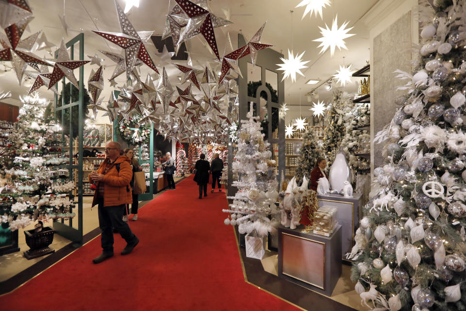 FILE - In this Tuesday, Nov. 5, 2019 file photo shoppers browse the Holiday Lane section at the Macy's flagship store, in New York. Macy’s cut its profit and sales expectations for the year after posting its first comparable store sales decline in almost two years, Thursday, Nov. 21. The company is citing the late arrival of colder weather, meager tourist business, weak traffic at some malls and problems on its website. (AP Photo/Richard Drew, File)