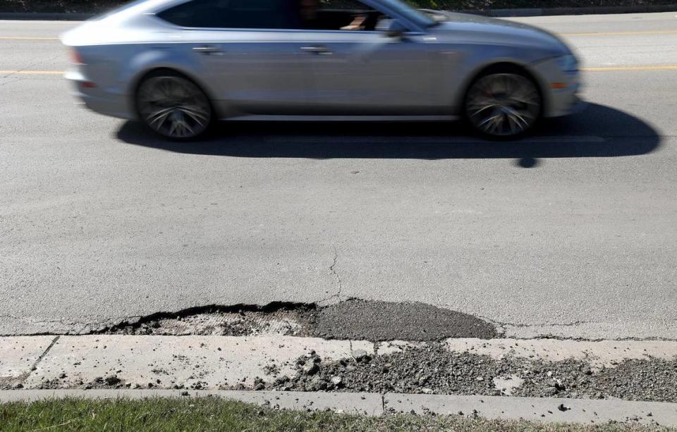 Vehicles pass potholes while driving north on 8th Street in Fort Worth on Tuesday, February 21, 2024.