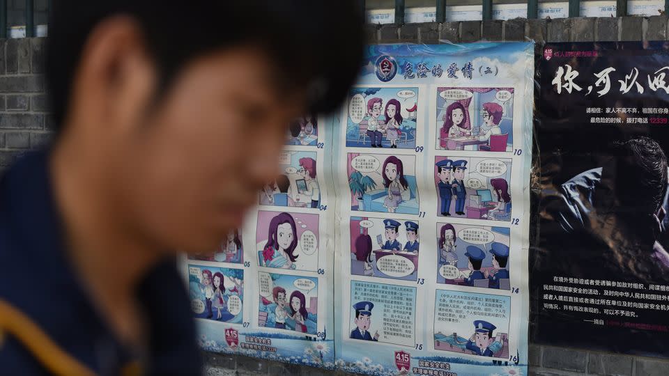 A man walks past a propaganda poster warning Chinese residents about foreign spies, in Beijing on May 23, 2017. - Greg Baker/AFP/Getty Images
