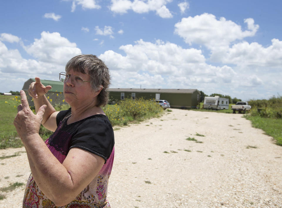 <p>Local resident Margaret Wylie describes a burst of flames she saw in the field across the road from her house at the scene of a hot air balloon crash near Lockhart, Texas, July 30, 2016. (Ralph Barrera/Austin American-Statesman via AP)</p>