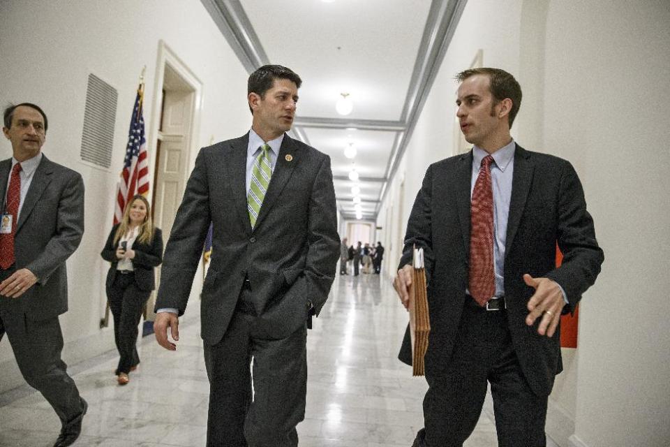 House Budget Committee Chairman Rep. Paul Ryan, R-Wis., center, confers with aide Conor Sweeney as he leaves a closed-door meeting on Capitol Hill in Washington, Wednesday, April 2, 2014, before a markup session where House Republicans will craft a slashing plan to try to balance the budget within 10 years. (AP Photo/J. Scott Applewhite)