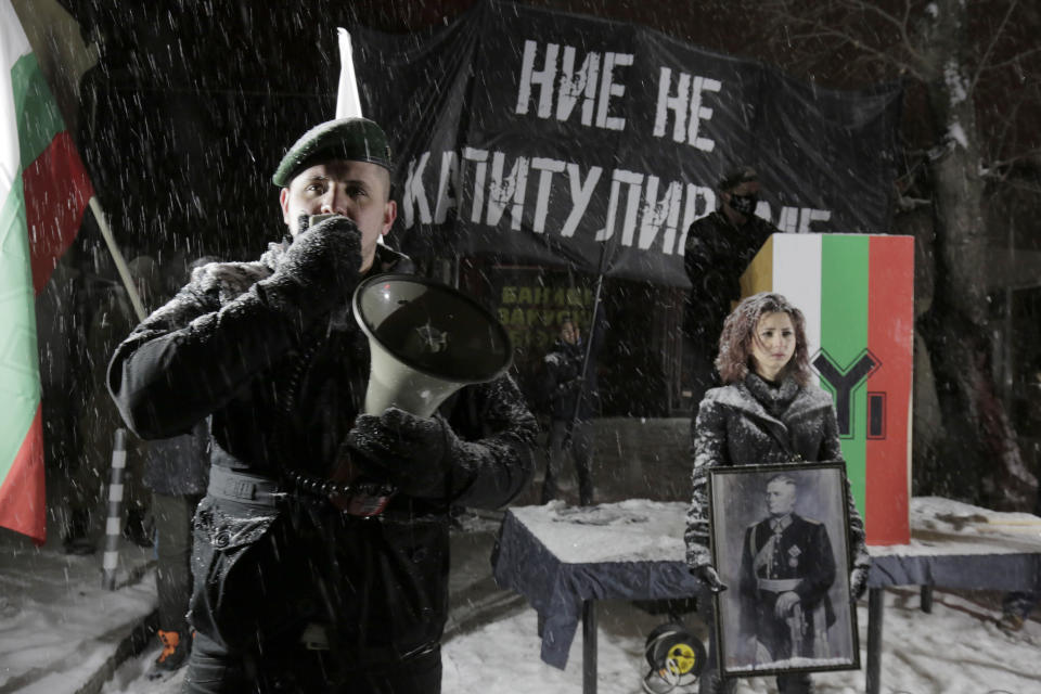 A far-right Bulgarian nationalist speaks on a megaphone during a gathering, in the country's capital, to honour a World War II general known for his anti-Semitic and pro-Nazi activities, in Sofia, Saturday, Feb. 13, 2021. Braving sub-zero temperatures, hundreds of dark-clad supporters of the Bulgarian National Union group flocked to a central square where they had planned to kick off the annual Lukov March, a torch-lit procession held every February to the former house of Gen. Hristo Lukov. (AP Photo/Valentina Petrova)