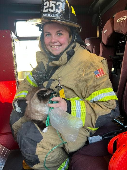 Firefighter Kayla Crim administers oxygen to a cat rescued from a fire Thursday in Delhi Township. The cat was taken to Ingham County Animal Control for further care.