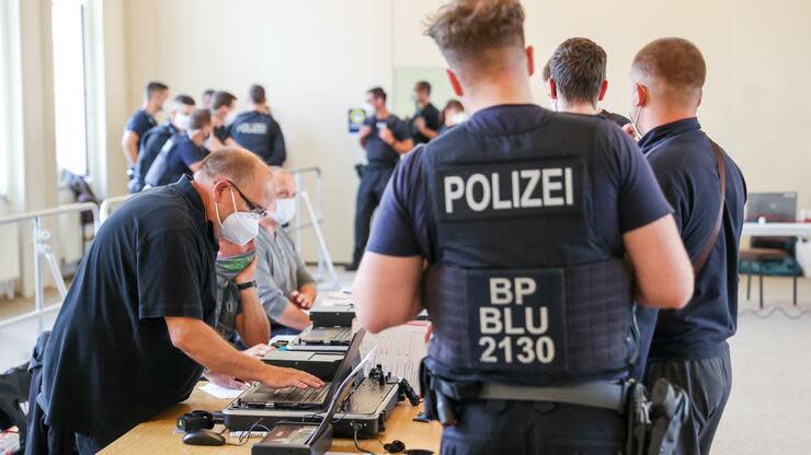 Ein Verdächtiger wird durch Beamte der Bundespolizei nach einer Razzia erkennungsdienstlich behandelt. Foto: dpa