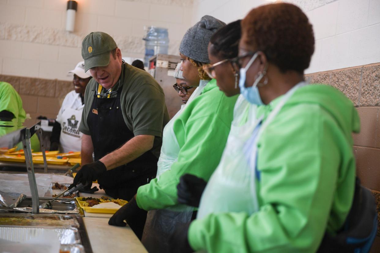 Cook at Golden Harvest Food Bank J.J. Tramontana shows volunteers how to put food on trays during the second annual MLK Day of Service at The Master's Table on Monday, Jan. 15, 2024. Golden Harvest Food Bank prepared to serve about 300 lunches, in addition to medical screenings by Augusta University students, and showers through Project Refresh.