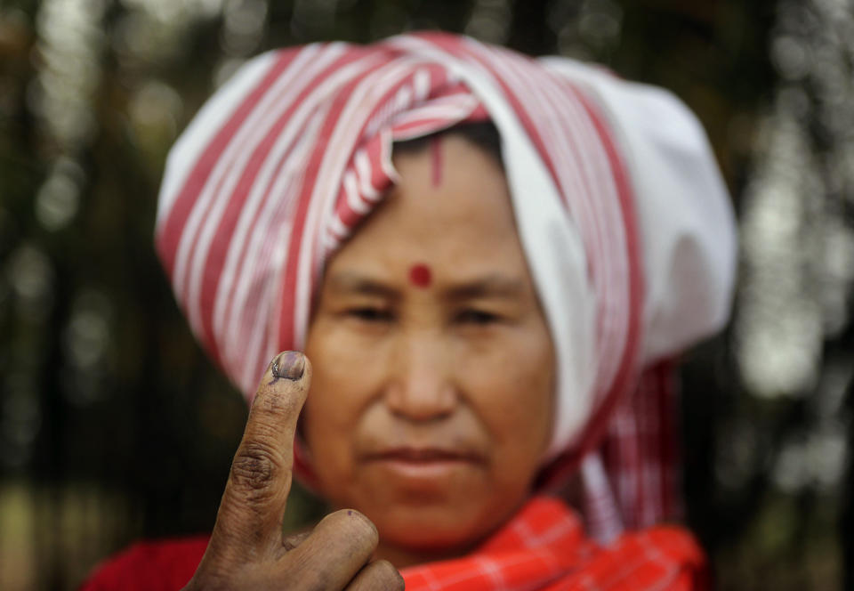 A Mishing tribal woman displays her indelible ink mark on her finger after casting her vote outside a polling station during the first phase of elections at Misamora Sapori, an island in the River Brahmaputra in the northeastern Assam state, India, Monday, April 7, 2014. (AP Photo/Anupam Nath)