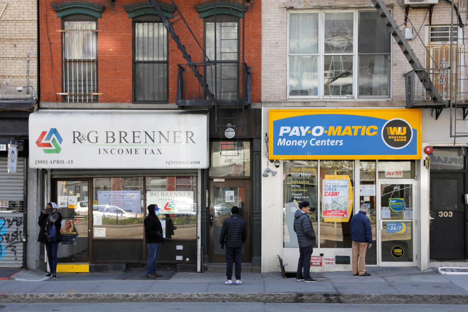 People queue to enter Payomatic, a business that offers check cashing, as unemployment claim figures were released, during the coronavirus disease (COVID-19) outbreak in Manhattan, New York City, New York, U.S., April 2, 2020. REUTERS/Andrew Kelly