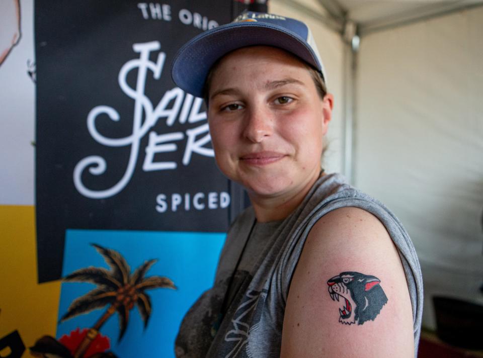 Chef Heske smiles after receiving her first tattoo from artist Christopher Waugh at the Louder Than Life music festival on Friday, Sept. 22, 2023