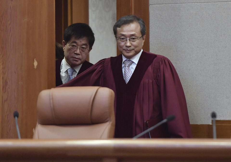 South Korea's Constitutional Court chief judge Yoo Nam-seok, right, arrives for the ruling on decriminalization of abortion at the court in Seoul Thursday, April 11, 2019. South Korea's Constitutional Court has ruled that a decades-long ban on abortions is incompatible with the constitution, setting up a likely easing of restrictions. (Jung Yeon-je /Pool Photo via AP)