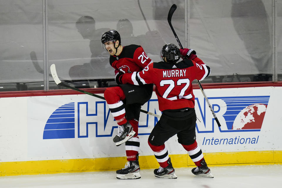 New Jersey Devils' Michael McLeod (20) celebrates with teammate Ryan Murray (22) after scoring his first career goal during the second period of an NHL hockey game against the Philadelphia Flyers Tuesday, Jan. 26, 2021, in Newark, N.J. (AP Photo/Frank Franklin II)