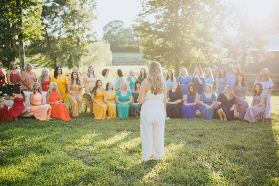 Photographer Ashley Sargent talks to the women and instructs them for a photograph celebrating and remember rainbow babies.