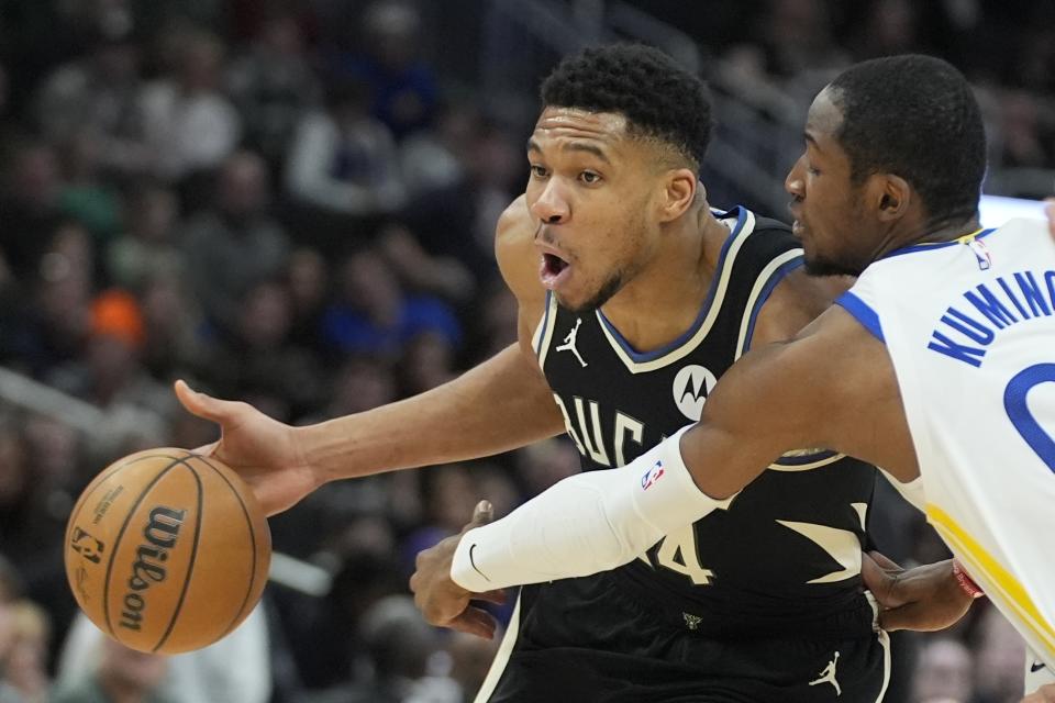 Milwaukee Bucks' Giannis Antetokounmpo tries to get past Golden State Warriors' Jonathan Kuminga during the first half of an NBA basketball game Saturday, Jan. 13, 2024, in Milwaukee. (AP Photo/Morry Gash)