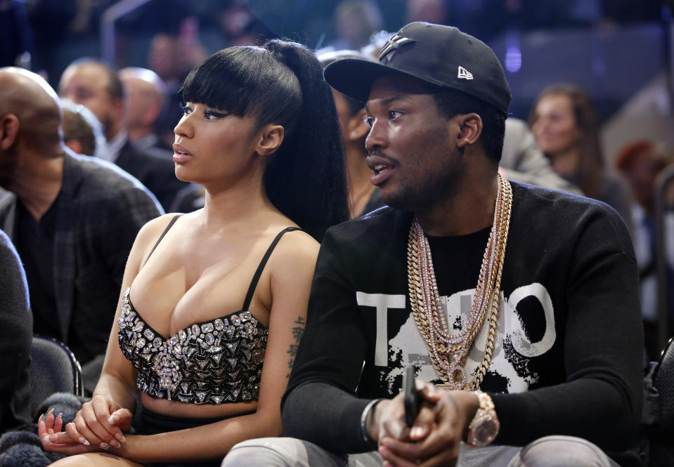 ARCHIVO - Nicki Minaj, a la izquierda, y Meek Mill miran la segunda mitad del partido de estrellas de la NBA, el 15 de febrero de 2015, en Nueva York. Así como la banda sonora de una película ayuda a los espectadores a seguir la acción de la narración a través de cada giro de la trama, el hip hop ha hecho lo mismo con el basquetbol a través de la NBA. (Foto AP/Kathy Willens, archivo)